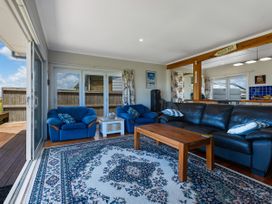 A living room with sofas and a coffee table at Karikari in Kaitaia