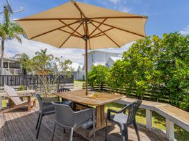 An outdoor dining area with a table and chairs at Sea Breezes - Matarangi Holiday Home in Whitianga