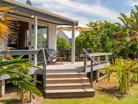 An outdoor deck area with steps and seating at Sea Breezes - Matarangi Holiday Home in Whitianga