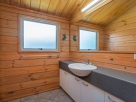 A bathroom with a sink and mirror at Sea Breezes - Matarangi Holiday Home, Whitianga