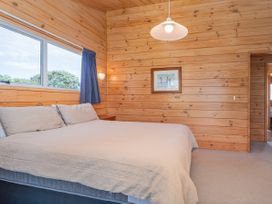 A bedroom with a bed and window at Sea Breezes - Matarangi Holiday Home Whitianga