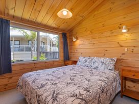 A bedroom with a bed and window at Sea Breezes - Matarangi Holiday Home in Whitianga