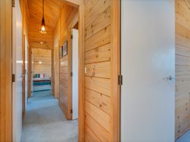 A hallway with doors and a light fixture at Sea Breezes - Matarangi Holiday Home in Whitianga