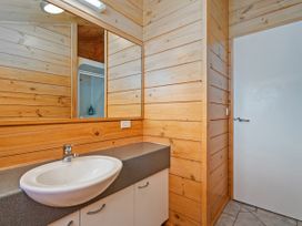 A sink with a mirror in a bathroom at Sea Breezes - Matarangi Holiday Home Whitianga