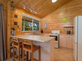 A kitchen with a countertop and stools at Sea Breezes - Matarangi Holiday Home Whitianga