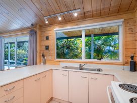 A kitchen with a sink and cabinets at Sea Breezes - Matarangi Holiday Home Whitianga