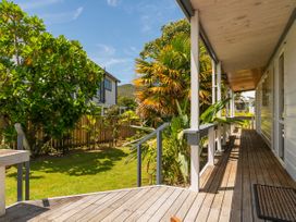 An outdoor deck area with plants and a view of the garden at Sea Breezes - Matarangi Holiday Home Whitianga