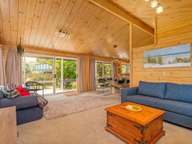 A living room with a coffee table and sofa at Sea Breezes - Matarangi Holiday Home in Whitianga