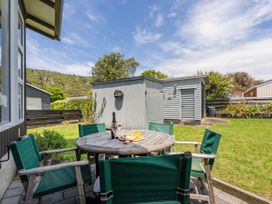 A table with chairs and a fruit platter outside at Matarangi Holiday Home Whitianga