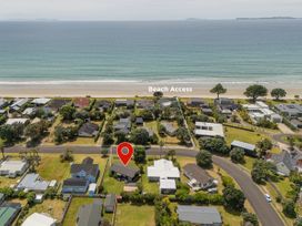 An aerial view of houses and beach access at Matarangi Holiday Home in Whitianga