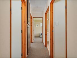 A hallway with doors leading to different rooms at Matarangi Holiday Home in Whitianga