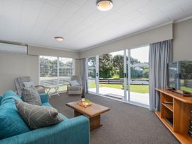 A living room with a sofa and coffee table at Matarangi Holiday Home Whitianga