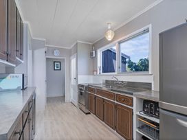 A kitchen with cabinets and appliances at Matarangi Holiday Home in Whitianga