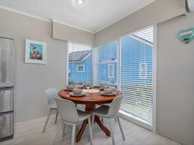 A dining room with a table set for meals at Matarangi Holiday Home in Whitianga