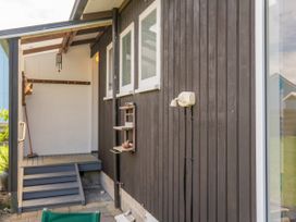 An exterior entryway with stairs and a wind chime at Matarangi Holiday Home in Whitianga
