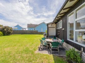 An outdoor dining area with a table and chairs at Matarangi Holiday Home Whitianga