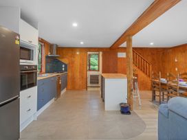 A kitchen with appliances and dining area at The Oak House - Coromandel