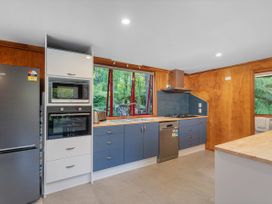 A kitchen with appliances and cabinets at The Oak House - Coromandel