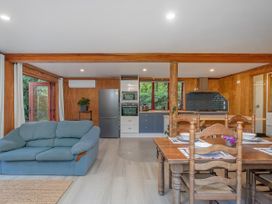 A kitchen with a sofa and dining area at The Oak House - Coromandel