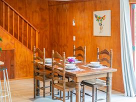 A dining room with a table and chairs at The Oak House - Coromandel