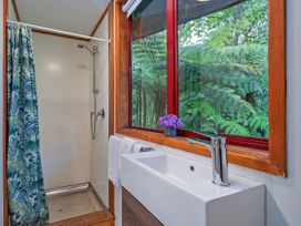 A bathroom with a shower and sink at The Oak House - Coromandel