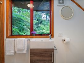 A bathroom with a sink, towels, and a window at The Oak House - Coromandel