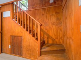 A staircase with wooden paneling and steps at The Oak House - Coromandel