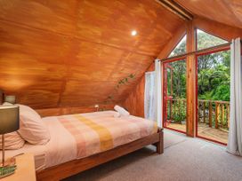 A bedroom with a bed and sliding door at The Oak House - Coromandel