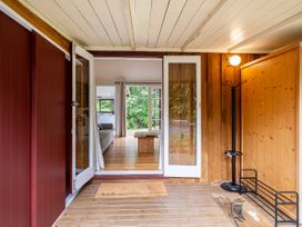 An entrance area with a coat rack and welcome mat at Stream-side Cottage - Driving Creek Coromandel
