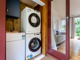 A laundry room with a washing machine and dryer at Stream-side Cottage - Driving Creek Coromandel