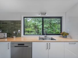 A kitchen with a sink and window at Stream-side Cottage - Driving Creek Coromandel