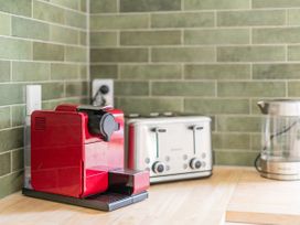 A kitchen with coffee machine, toaster, and kettle at Stream-side Cottage - Driving Creek Coromandel