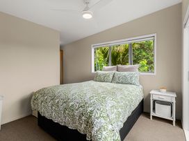 A bedroom with a bed and nightstand at Waipu Holiday Home in Waipu