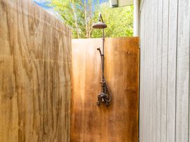 An outdoor shower area with wooden walls at Waipu Holoday Home in Waipu