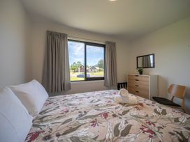A bedroom with a bed and window at Te Anau Holiday Home in Te Anau