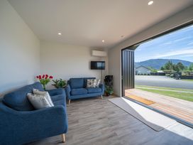A living room with furniture and a view outside at Te Anau Holiday Home in Te Anau