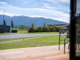 A view of mountains and houses from a deck at Te Anau Holiday Home in Te Anau
