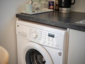 A washing machine next to a kitchen countertop at Te Anau Holiday Home in Te Anau
