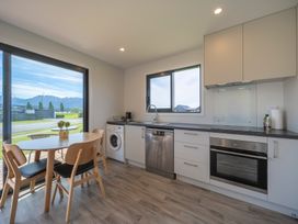 A kitchen with a dining table and chairs at Te Anau Holiday Home in Te Anau