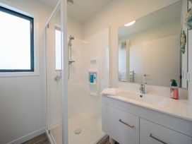 A bathroom with a shower and sink at Te Anau Holiday Home in Te Anau