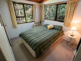 A bedroom with a bed and lamp at Seabreeze Hideaway - Golden Bay Holiday Home in Collingwood