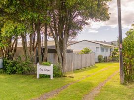 An outdoor view of Cozy Cottage with a pathway and trees in Whitianga