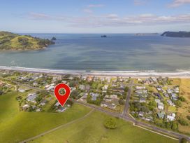 An aerial view of a coastal area with houses near the beach at Cozy Cottage - Whitianga Holiday Home, Whitianga