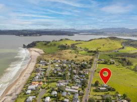 An aerial view of a coastal area with houses and hills at Cozy Cottage - Whitianga Holiday Home Whitianga