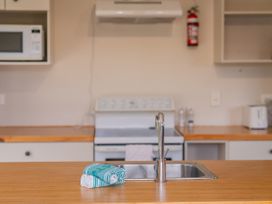 A kitchen with a sink and appliances at Cozy Cottage - Whitianga Holiday Home in Whitianga