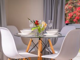 A dining table with plates and glasses at Cozy Cottage - Whitianga Holiday Home Whitianga
