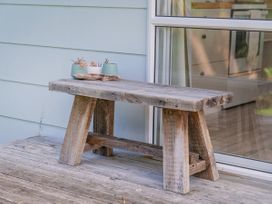 A bench with decorative bowls on top at Cozy Cottage - Whitianga Holiday Home in Whitianga