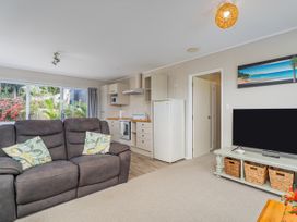 A living room with a sofa and television at Cozy Cottage - Whitianga Holiday Home in Whitianga