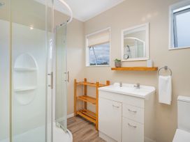 A bathroom with a shower and sink at Cozy Cottage - Whitianga Holiday Home in Whitianga