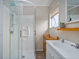 A bathroom featuring a shower stall and vanity at Cozy Cottage - Whitianga Holiday Home in Whitianga